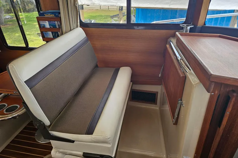 Slide: The Image of Interior seating of 2014 Ranger Tugs R-31 CB boat with wood accents and window view. - 9