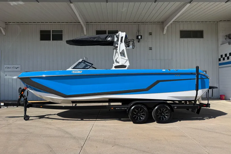 The Image of 2025 Nautique Super Air Nautique GS24 boat in vibrant blue on trailer. - 1