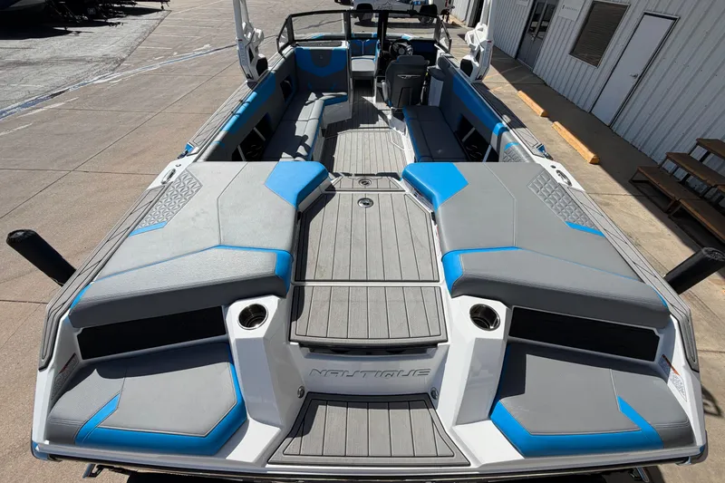 Slide: The Image of 2025 Nautique Super Air Nautique GS24 boat interior with gray and blue seating. - 10