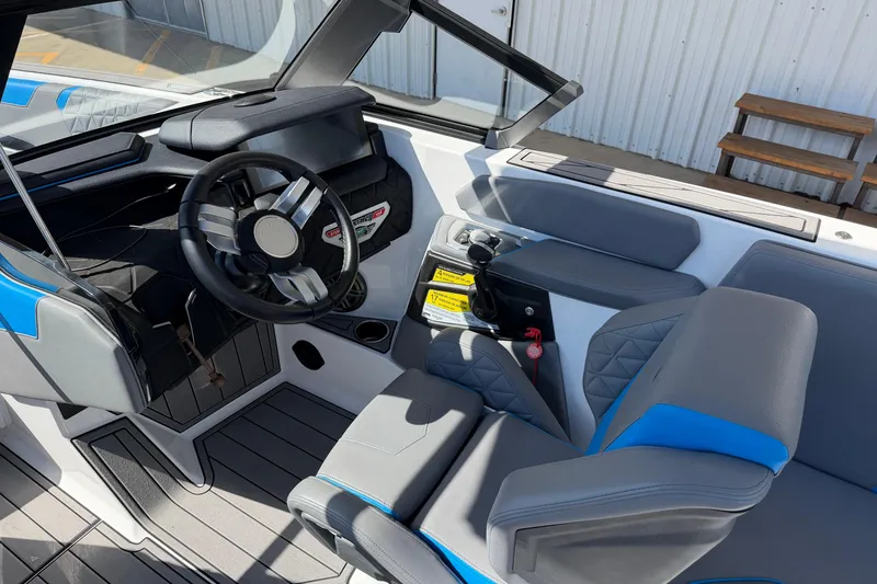 Slide: The Image of 2025 Nautique Super Air Nautique GS24 boat interior with steering wheel and seating. - 12