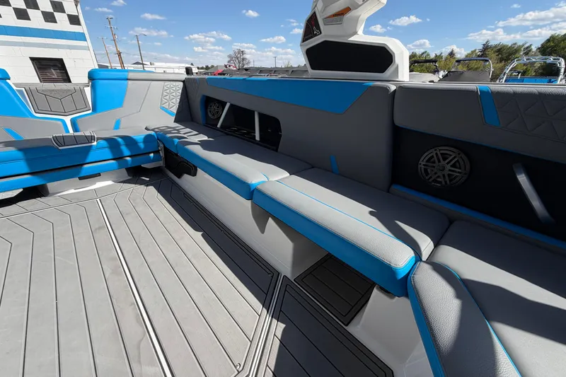Slide: The Image of 2025 Nautique Super Air Nautique GS24 interior with blue and gray seating, modern design. - 15
