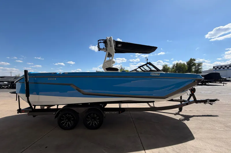 Slide: The Image of 2025 Nautique Super Air Nautique GS24 boat on trailer under clear blue sky. - 7