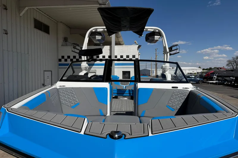 Slide: The Image of 2025 Nautique Super Air Nautique GS24 boat with blue and gray interior, docked outdoors. - 9