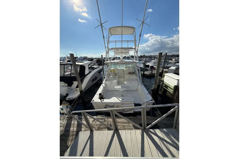 The Image of 2009 Cabo 35 Express yacht docked at marina under clear blue sky. - 0