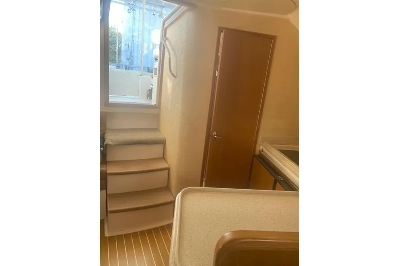 Slide: The Image of Interior view of 2009 Cabo 35 Express yacht with stairs and wooden door. - 11