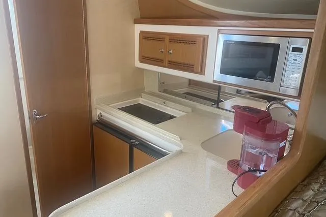 Slide: The Image of 2009 Cabo 35 Express yacht kitchen with microwave, sink, and storage cabinets. - 12