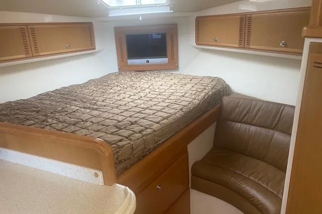 Slide: The Image of 2009 Cabo 35 Express cabin interior with bed, seating, and storage cabinets. - 14