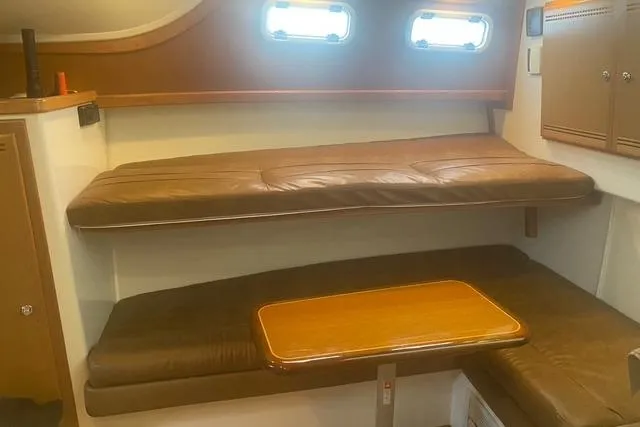 Slide: The Image of Interior of 2009 Cabo 35 Express boat with leather seating and wooden table. - 16