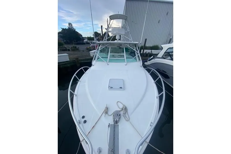 Slide: The Image of 2009 Cabo 35 Express boat docked, showcasing sleek design and spacious deck. - 19