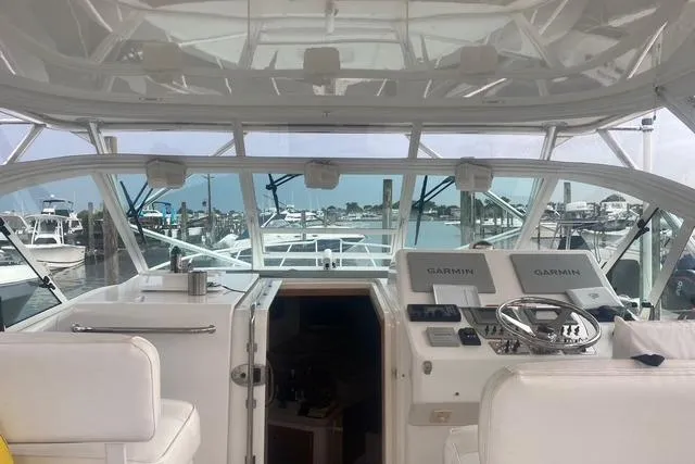 Slide: The Image of 2009 Cabo 35 Express yacht interior with helm, docked at marina. - 21