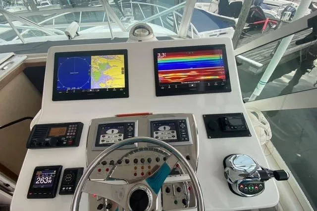 Slide: The Image of Control panel of a 2009 Cabo 35 Express boat with navigation screens and controls. - 22