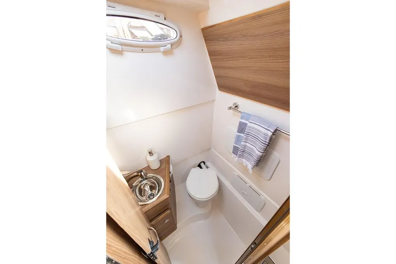 Slide: The Image of Manufacturer Provided Image: Compact bathroom in 2025 Solara S-310 CW boat with modern fixtures and wood accents. - 27