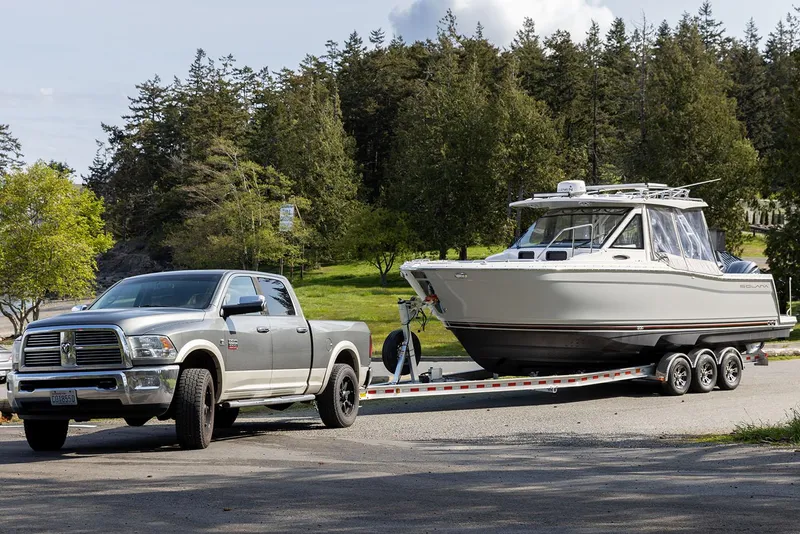 Slide: The Image of Manufacturer Provided Image: Truck towing 2025 Solara S-310 CW boat on a trailer in a scenic park. - 28