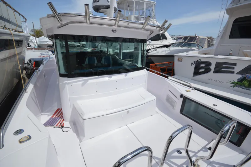 Slide: The Image of 2024 Axopar 37 XC Cross Cabin boat docked, showcasing sleek design and spacious deck. - 10