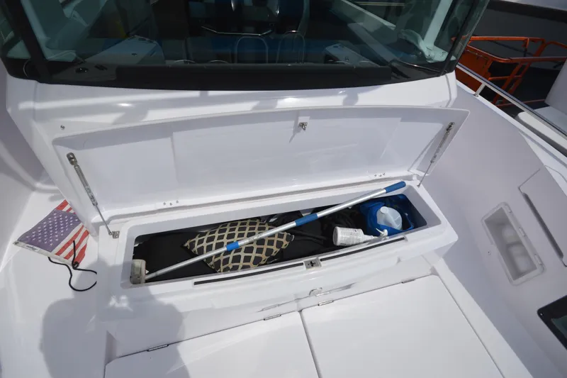 Slide: The Image of 2024 Axopar 37 XC Cross Cabin storage compartment with cleaning tools and accessories. - 11