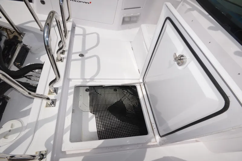 Slide: The Image of 2024 Axopar 37 XC Cross Cabin storage compartment with open hatch and stainless steel railings. - 15