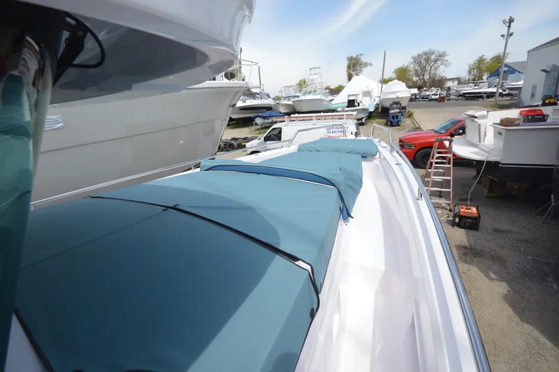 Slide: The Image of 2024 Axopar 37 XC Cross Cabin boat with blue covers in a marina setting. - 17