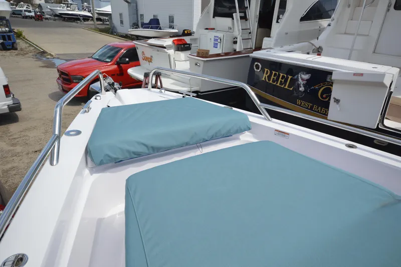 Slide: The Image of 2024 Axopar 37 XC Cross Cabin with teal cushions docked near other boats. - 18