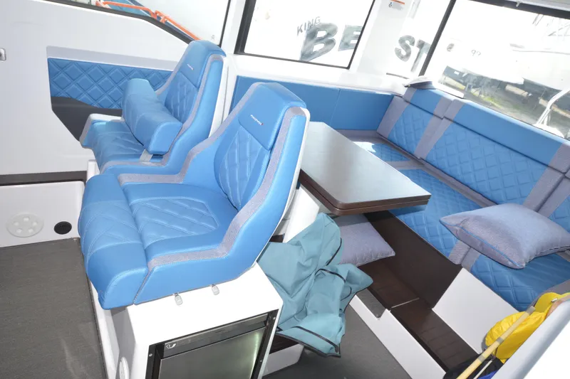 Slide: The Image of Interior of 2024 Axopar 37 XC Cross Cabin with blue seating and table. - 19
