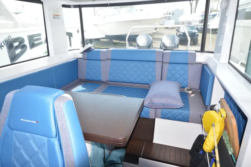 Slide: The Image of 2024 Axopar 37 XC Cross Cabin interior with blue seating and table. - 20