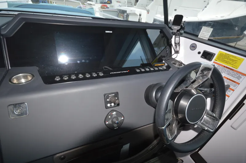 Slide: The Image of 2024 Axopar 37 XC Cross Cabin dashboard with steering wheel and control panel. - 23