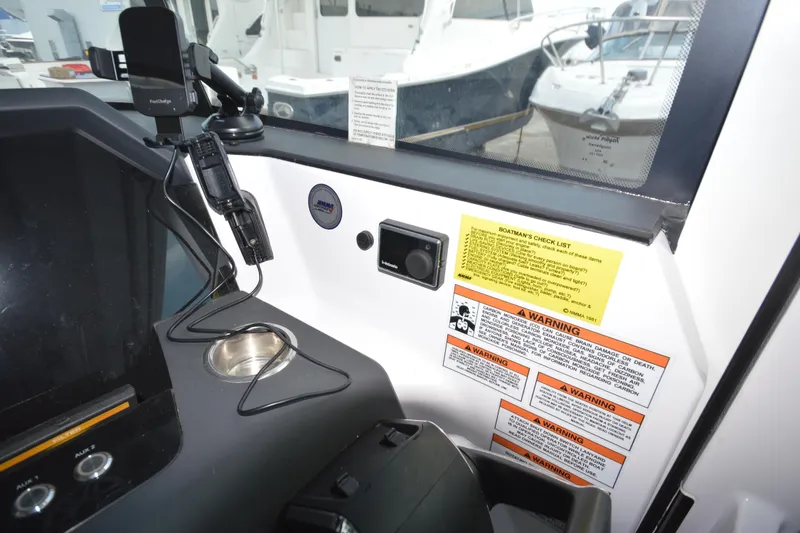 Slide: The Image of 2024 Axopar 37 XC Cross Cabin dashboard with safety warnings and device holder. - 24