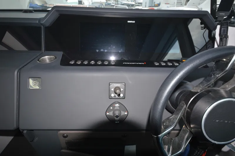 Slide: The Image of 2024 Axopar 37 XC Cross Cabin dashboard with steering wheel and control panel. - 26