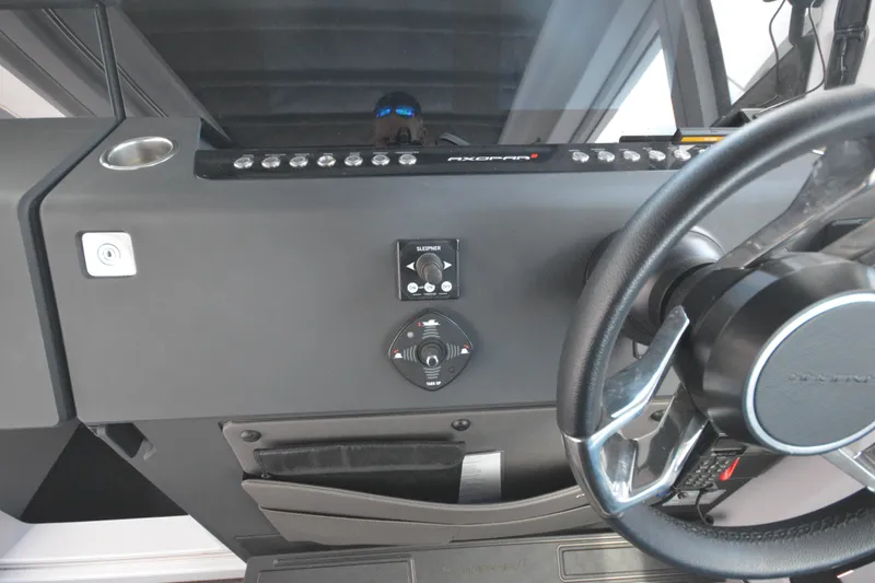 Slide: The Image of 2024 Axopar 37 XC Cross Cabin dashboard with steering wheel and control panel. - 27