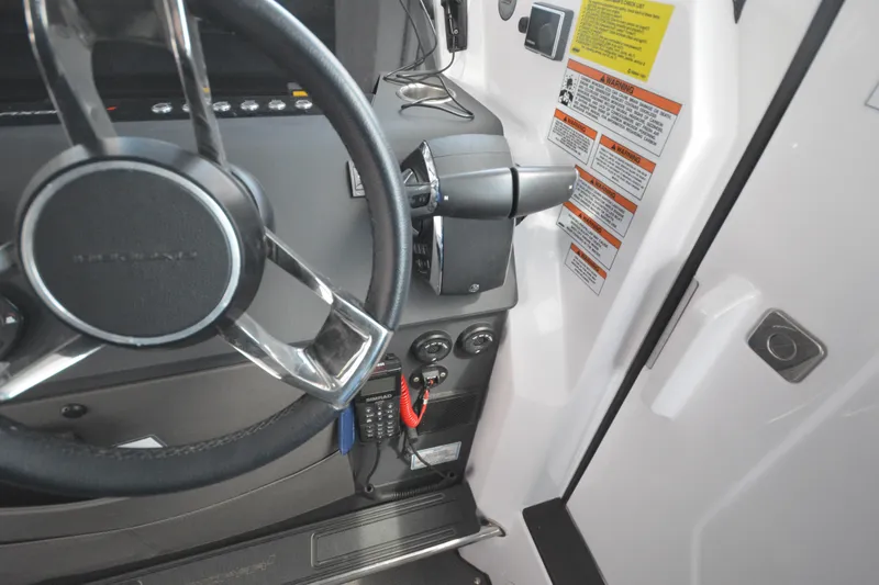 Slide: The Image of 2024 Axopar 37 XC Cross Cabin steering wheel and control panel close-up. - 28