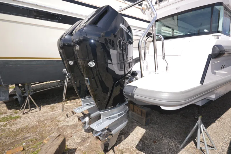 Slide: The Image of 2024 Axopar 37 XC Cross Cabin with dual Mercury outboard engines, docked on land. - 3