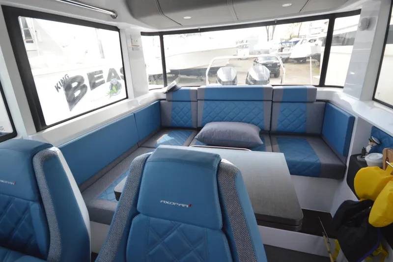 Slide: The Image of Interior of 2024 Axopar 37 XC Cross Cabin with blue seating and large windows. - 30