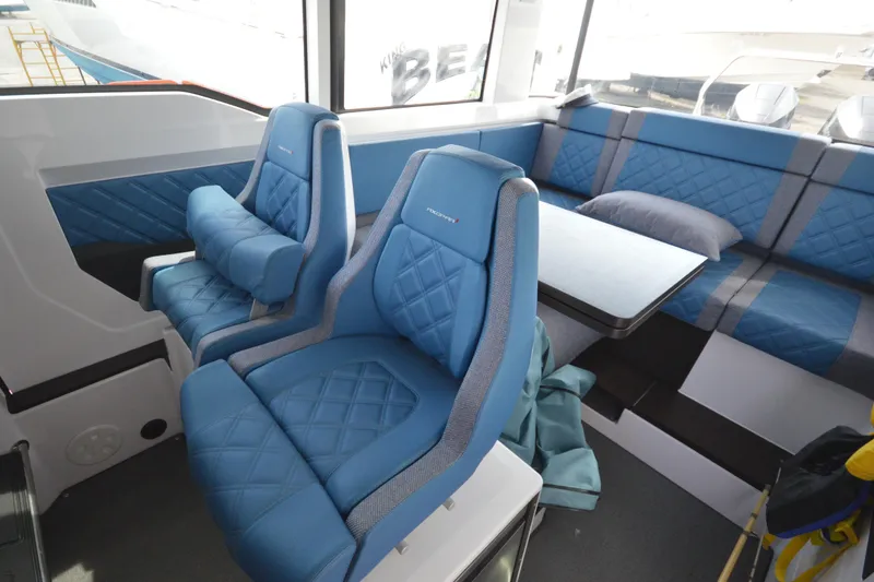 Slide: The Image of 2024 Axopar 37 XC Cross Cabin interior with blue seating and table. - 31