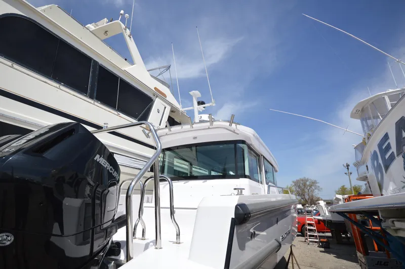 Slide: The Image of 2024 Axopar 37 XC Cross Cabin boat with Mercury engine, docked under clear blue sky. - 4