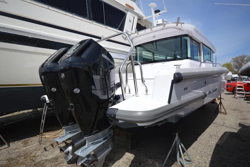 Slide: The Image of 2024 Axopar 37 XC Cross Cabin with dual Mercury outboard engines, docked on land. - 43