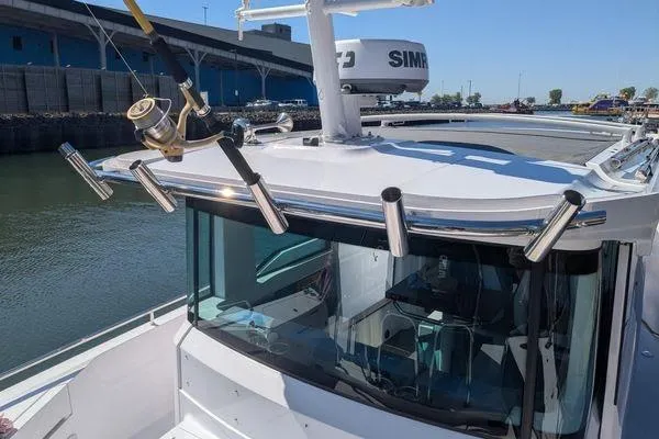 Slide: The Image of 2024 Axopar 37 XC Cross Cabin boat with fishing rod holders and radar equipment. - 49