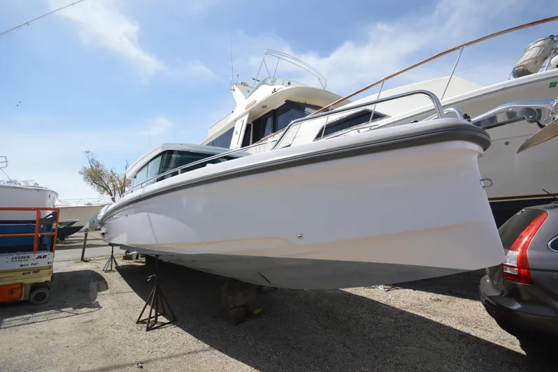 Slide: The Image of 2024 Axopar 37 XC Cross Cabin boat displayed on a trailer in a marina. - 6