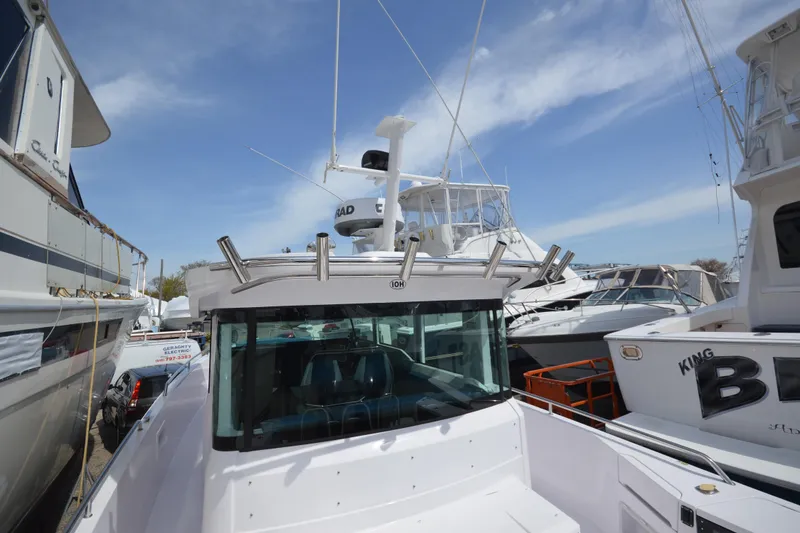 Slide: The Image of 2024 Axopar 37 XC Cross Cabin boat docked among other vessels. - 9