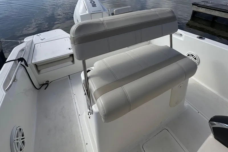 Slide: The Image of 2023 Boston Whaler 220 Dauntless boat interior with cushioned seating and storage compartments. - 13