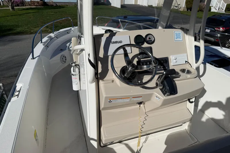 Slide: The Image of 2023 Boston Whaler 220 Dauntless boat console with steering wheel and navigation controls. - 3