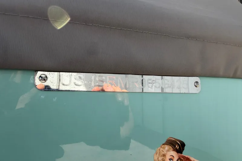 Slide: The Image of 2025 Moomba Mojo boat identification plate with screws on a teal surface. - 24