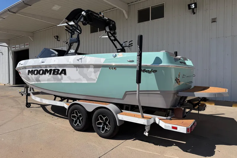 Slide: The Image of 2025 Moomba Mojo boat on trailer, parked outside a building, showcasing sleek design. - 3