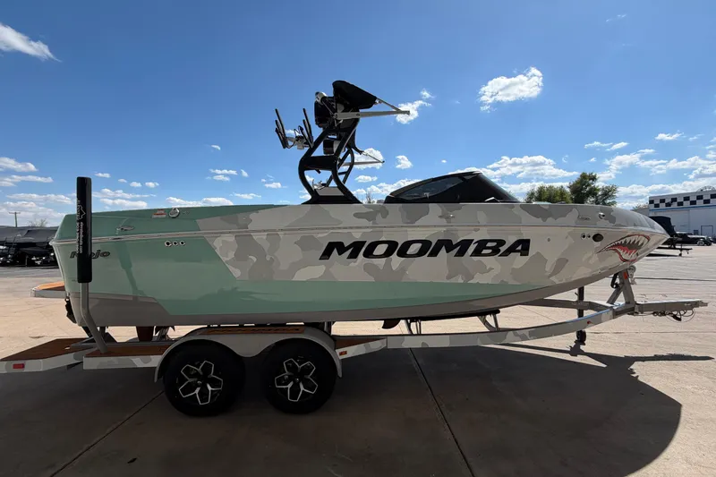 Slide: The Image of 2025 Moomba Mojo boat with camouflage design on a trailer under a clear blue sky. - 6