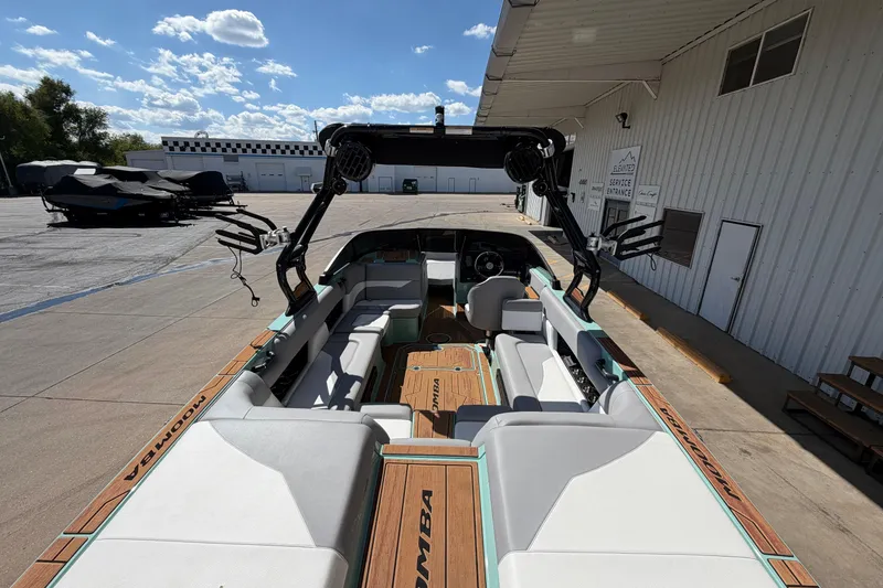 Slide: The Image of 2025 Moomba Mojo boat with spacious seating and modern design at a marina. - 9
