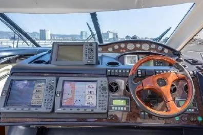 Slide: The Image of Cockpit of 2003 Viking Princess 65 yacht with navigation instruments and wooden steering wheel. - 14