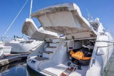 Slide: The Image of 2003 Viking Princess 65 yacht with open garage and jet ski, docked at marina. - 2