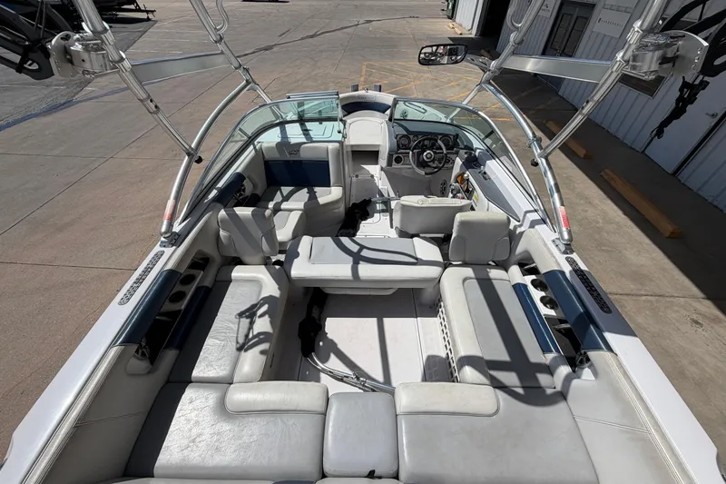 Slide: The Image of 2007 Nautique Crossover 236 boat interior with seating and steering wheel, docked outdoors. - 10