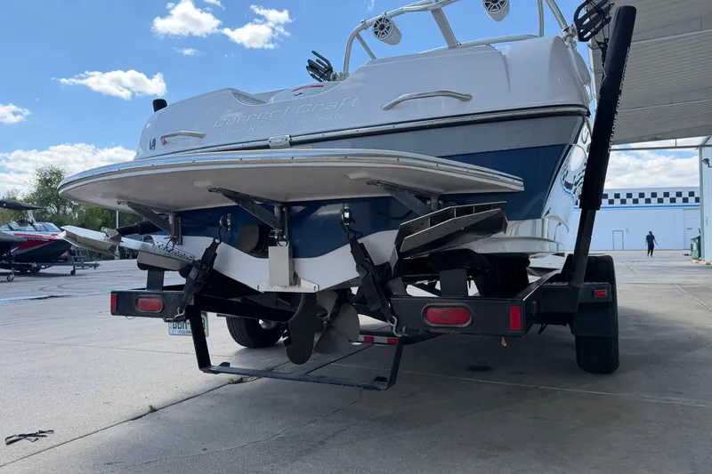 Slide: The Image of 2007 Nautique Crossover 236 boat on trailer, rear view, outdoors under blue sky. - 5