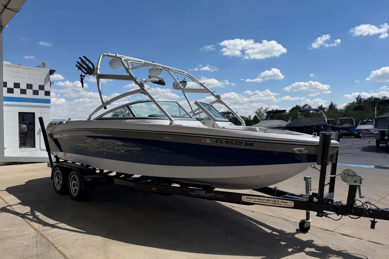Slide: The Image of 2007 Nautique Crossover 236 boat on trailer under clear blue sky. - 7