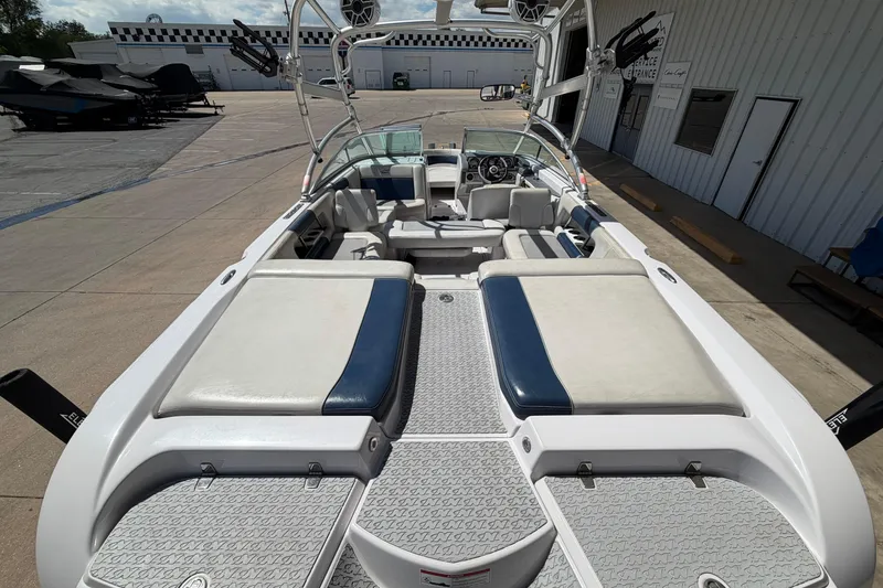 Slide: The Image of 2007 Nautique Crossover 236 boat interior with seating and wakeboard tower, docked at marina. - 9