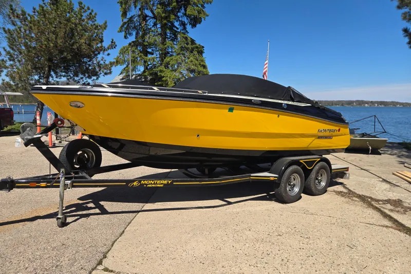 Slide: The Image of 2014 Monterey 214SS Super Sport boat on trailer by a lake, vibrant yellow color. - 2
